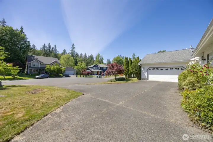 Another view of the large driveway and parking pad for RV or boat with the cul-de-sac beyond.