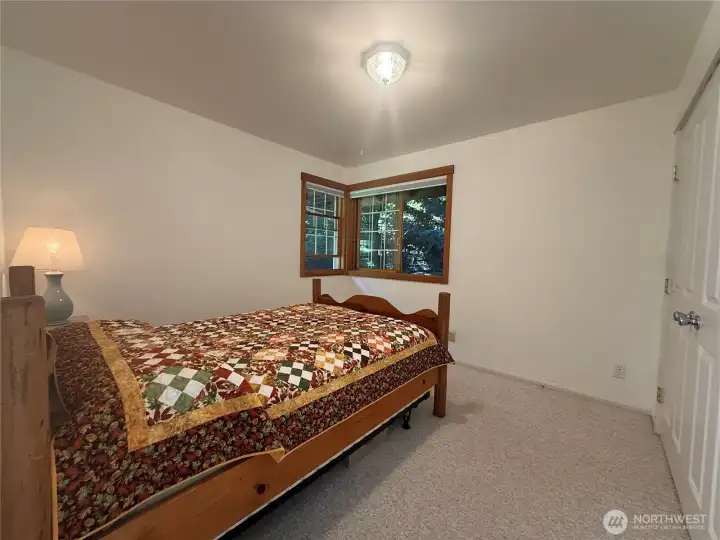Guest room with wood-cased corner windows and a large closet. Guest room with wood-cased corner windows and a large closet.