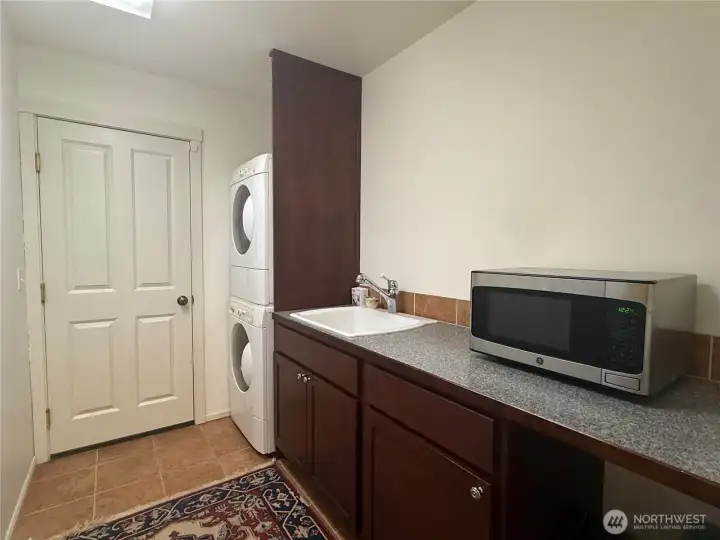 Dedicated laundry room/mudroom with full sink, storage and folding countertops. The door in the photo leads to the attached garage. Dedicated laundry room/mudroom with full sink, storage and folding countertops. The door in the photo leads to the attached garage.