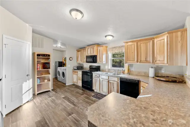 Farm house Kitchen tastefully finished wity Alder wood cabinets, Vinyl Plank floors, Tons of counter top areas. Pantry. All kitchen appliances. Double Stainless kitchen sink. Refrigerator, Range/Oven, DW/ MW/ Air fryer.