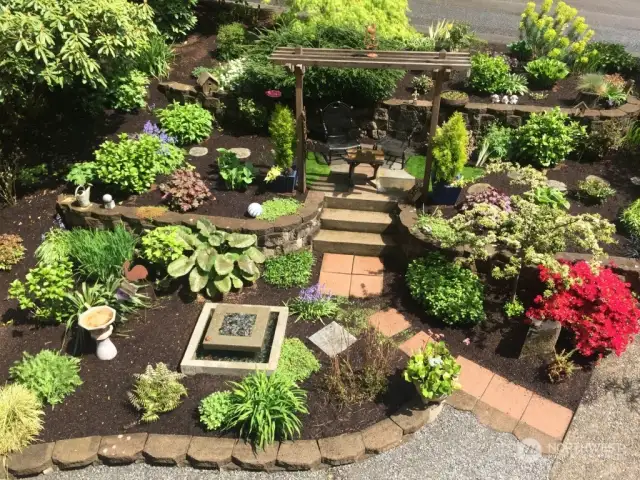 This roof top view of the stunning front garden in early spring shows off the lush plantings, patio and trellis. All of the pots on the property will stay for the new owner! You will be able to enjoy this lovely space for years to come! Welcome Home!