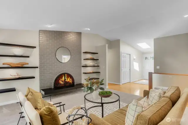 With a choice of gas logs or wood, the fireplace warms this space with floor to ceiling brick and a hearth made of "Absolute Black" honed granite. The floating display shelves all have architectural spot lights.