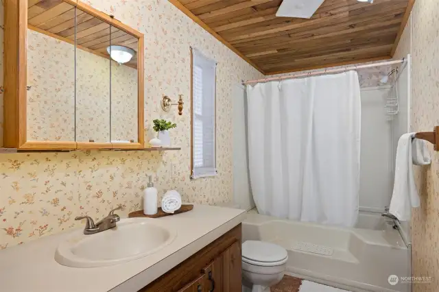 The primary bath has an oversized, oval tub and shower with a lot of storage at the vanity as well as a linen closet.