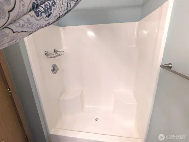 Low step shower with two seats in ensuite primary bath