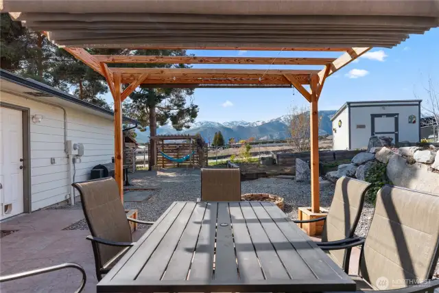 This arbor over the dining table has a sliding roof cover and a pull down shade on the west end to set the stage for comfortable outdoor dining no matter the weather.