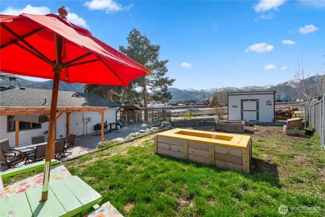 The upper terrace has raised garden beds a big shed, and a creatively designed raised pond.