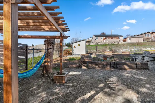 Another arbor, next to a privacy fence, provides shade for a lazy afternoon in the hammock!