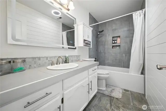 Full bath downstairs w/new tub, tile surround, toilet, flooring & counters