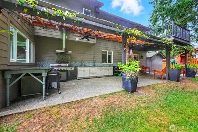 Outdoor kitchen w/BBQ that stays, sink w/hot & cold water, ceiling fans and string lights