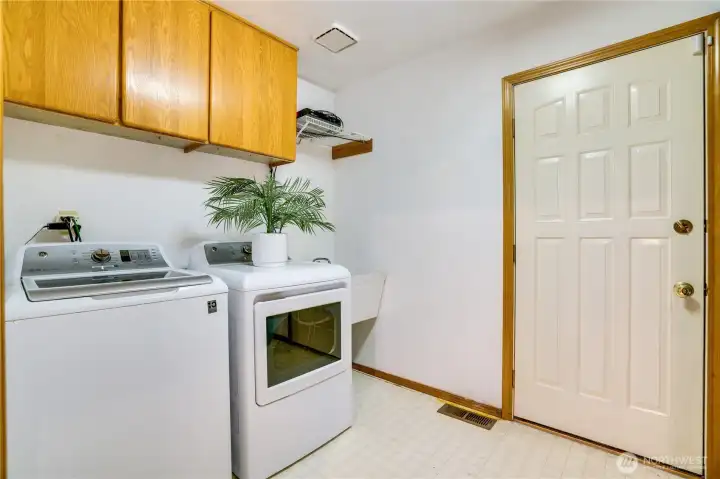 Large utility room has cabinets and located on the main floor