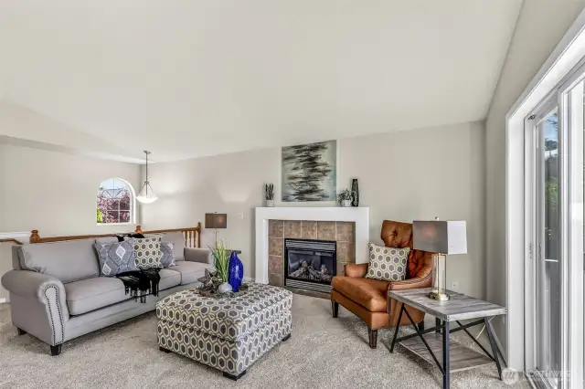 Another view of the living area showcases its generous scale and the contemporary fireplace surround. The layout lends itself to easy conversation and movement toward the adjacent dining area and the deck for fresh air.