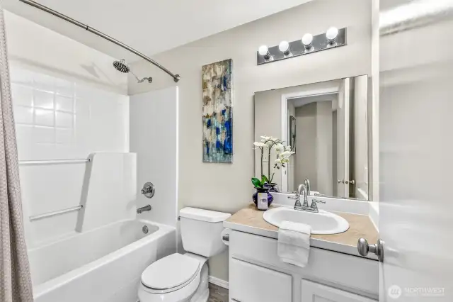 Upper-level full bath with a curved shower rod, and bright lighting. Neutral finishes make it easy to personalize while maintaining a fresh, move-in-ready feel.