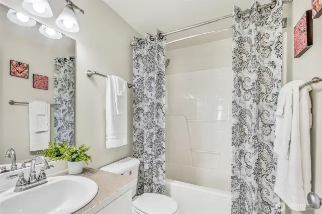 Hall full bath serving the secondary bedrooms. Bright vanity lighting, neutral counters, and tub/shower provide everyday convenience for busy mornings.