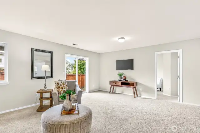 Lower-level living extends toward the backyard through the sliding door—perfect for casual entertaining.