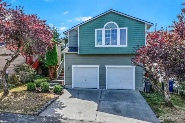 Inviting Bothell façade framed by mature landscaping and an arched upper window. Fresh exterior paint and a 2023 roof complement the two-car garage and wide driveway, offering easy parking on a low-maintenance 3,200 SF lot in the Everett School District.