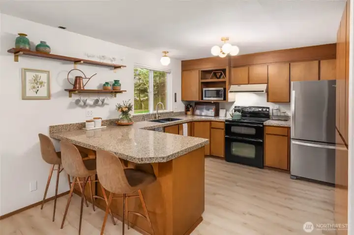 The kitchen feqtures solid wood cabinetry with a mid-century feel and its large countertop also serves as a breakfast bar.