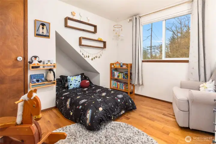 One of the bedrooms on the upper floor features hardwood floors.