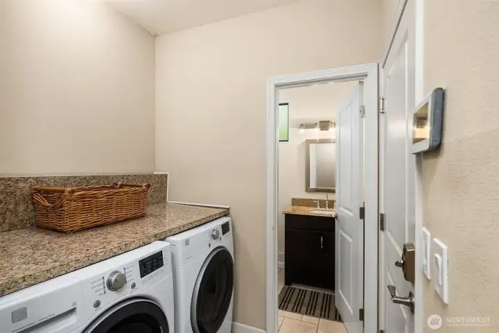 Landry room with handy countertop and adjacent, updated bathroom.