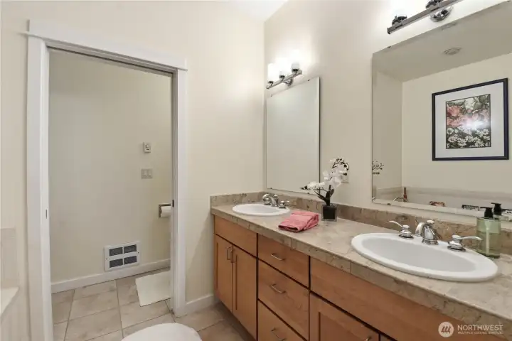 Dual vanity with tiled counter and floors.