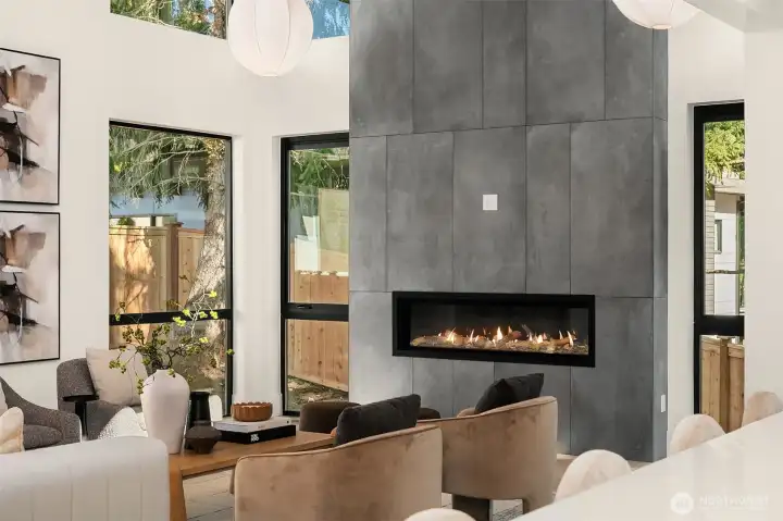 A 62" Napoleon linear gas fireplace clad in floor-to-ceiling concrete tile serves as the centerpiece.