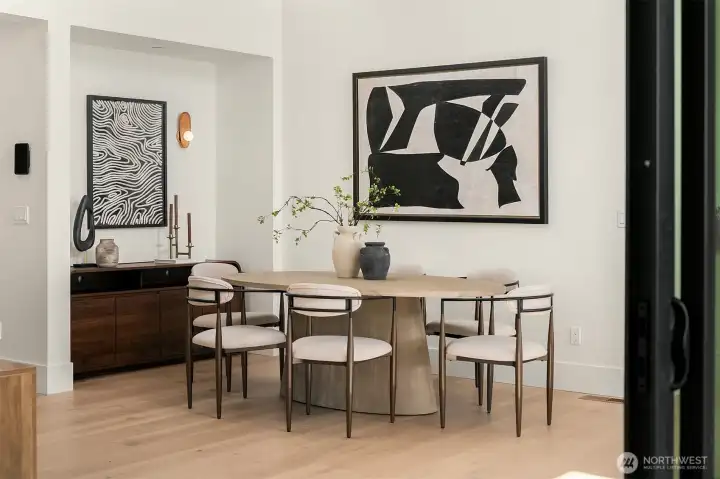 Kitchen flows seamlessly into the dining area with soaring ceilings and abundant natural light.