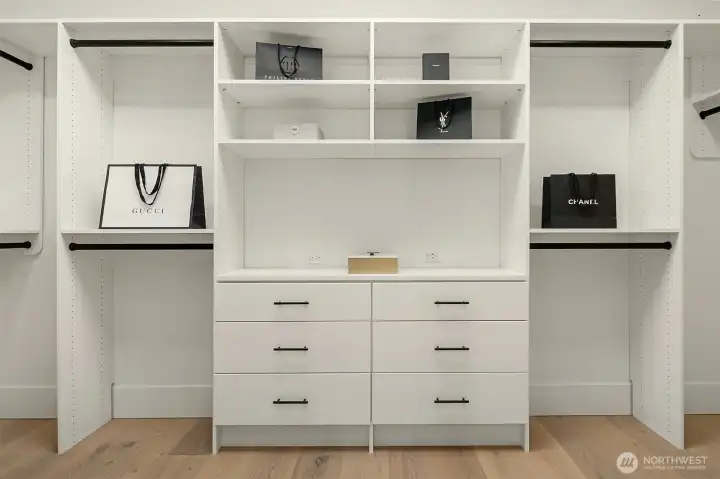 Natural light streams through the large skylight, highlighting the impressive size and design of the primary closet with custom organizers.