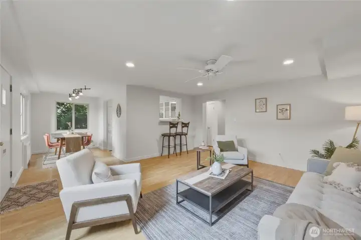 An inviting open-concept living space with oversized windows, warm flooring, and abundant natural light—perfect for relaxing or entertaining.