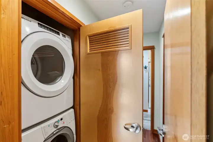 Stacked laundry units are located in the primary bedroom