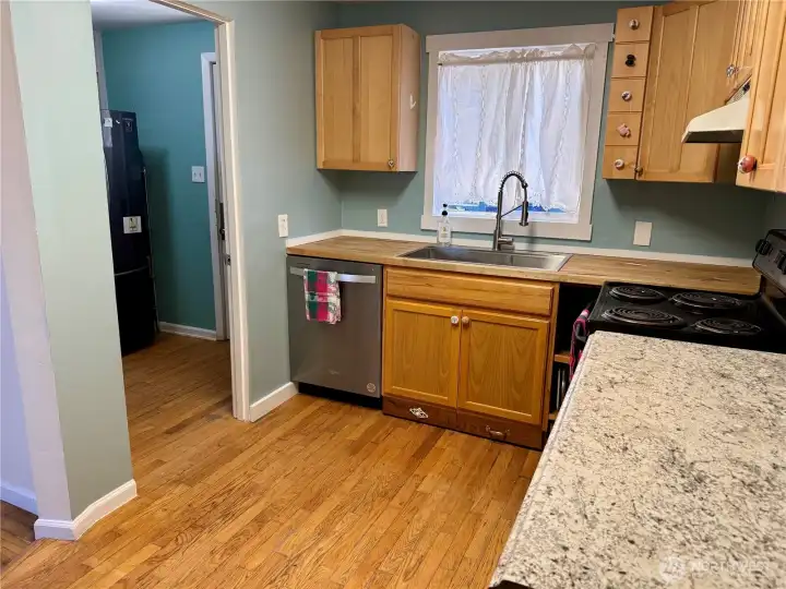 Well thought out kitchen. Open door leads to the stack washer and drwer af the refrigeratot  As well as a door that leads outside to one of the 2 patios!