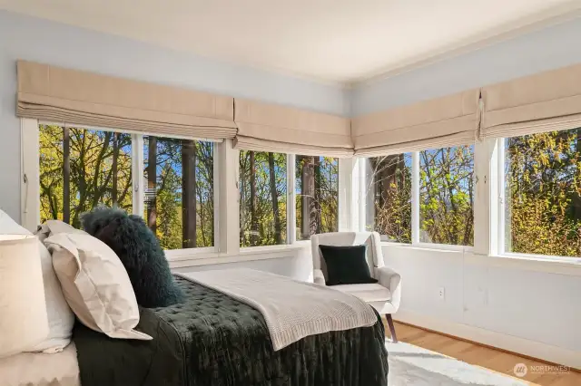 The main floor ensuite bedroom overlooks the preserved woodland and includes custom 'black out' roman shades.