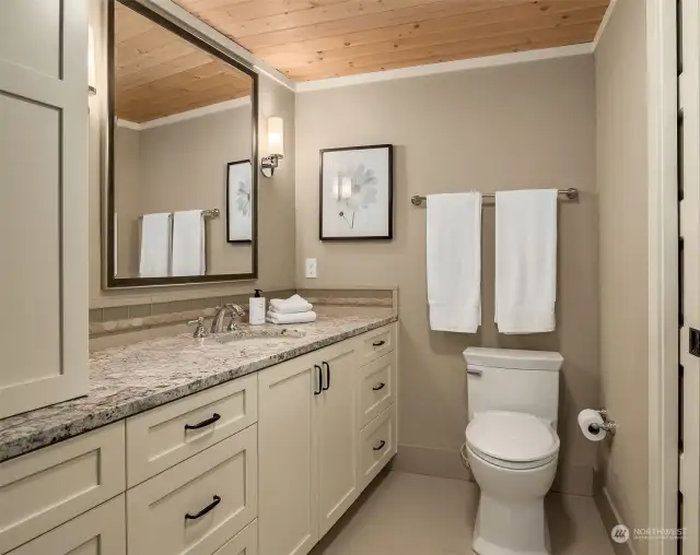 The lower level bedroom includes an ensuite bath with heated tile floors, stone countertops, heated toilet seats and luxurious shower.