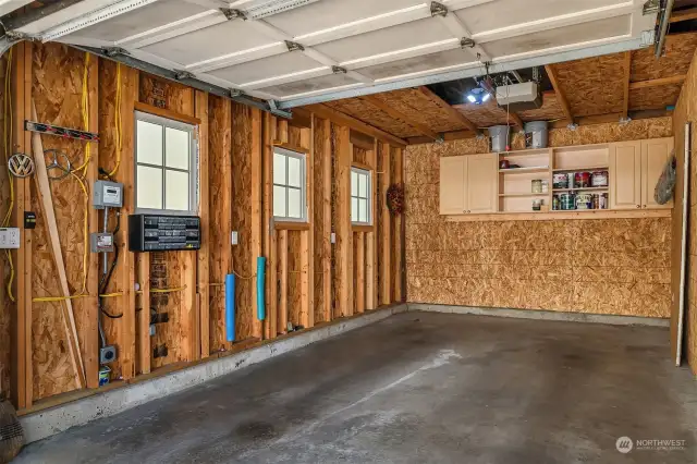 The large garage includes storage cabinets and an Electric Vehicle charging station!