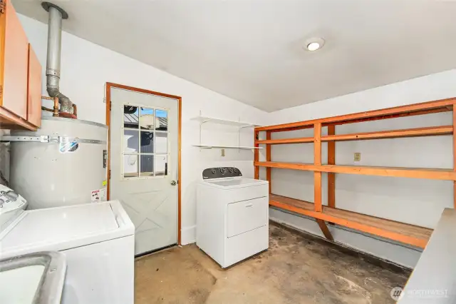 LARGE UTILITY ROOM with interior and exterior access  Washer and Dryer / Folding counter with storage cabinets  Built in storage shelves / Vintage utility Sink  Water heater location  Detached garage/shop opener