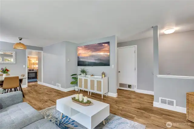 View of the living room facing the central hallway. Fresh paint and  stylish  vinyl plank flooring throughout.