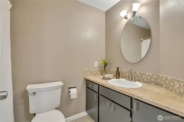 Main hall bathroom is centrally located in the home for easy access. The flooring is ceramic tile.