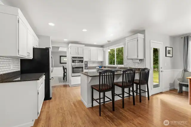 Spacious kitchen with granite countertops and eating bar.