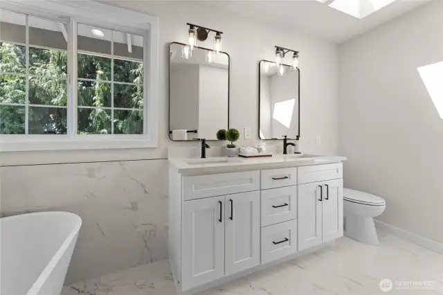 Duel vanities with quartz counters and skylight for natural lighting