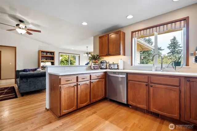 A view from the kitchen into the family room and breakfast nook area where the hardwoods continue with more of the gorgeous vaulted ceiling complete with a ceiling fan.