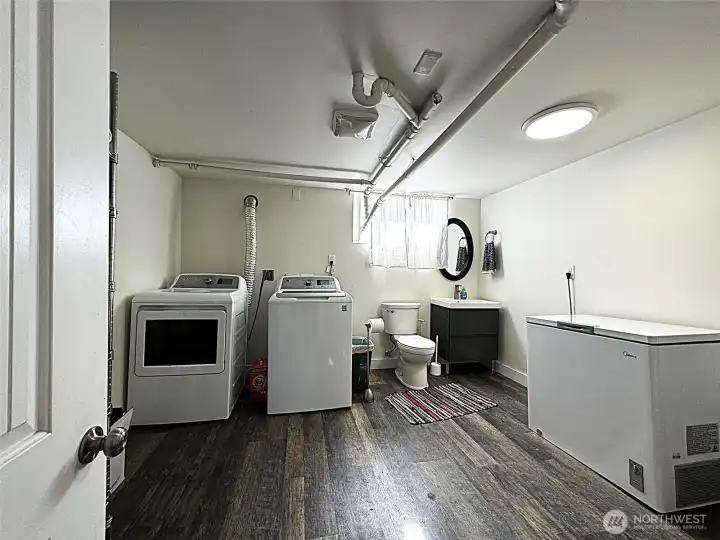 Downstairs features a spacious laundry room and half bathroom with ample space and storage.