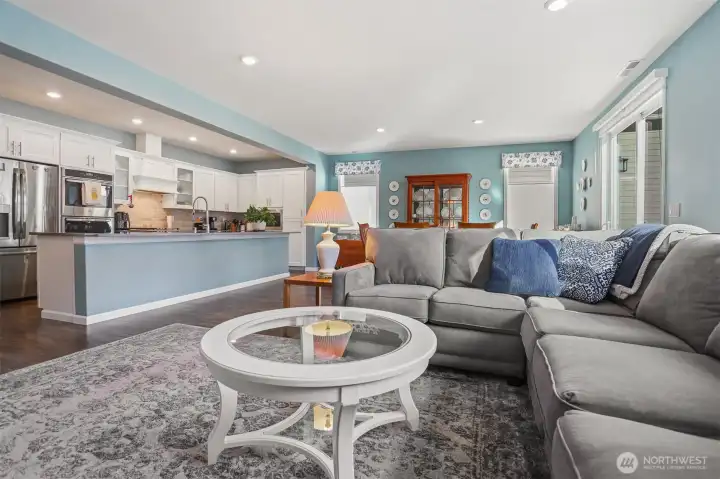 Main floor great room with a formal living room featuring a gas fireplace opens to the kitchen and dining room with sliding door to the back deck with Cascade Mountain views and southern exposure.