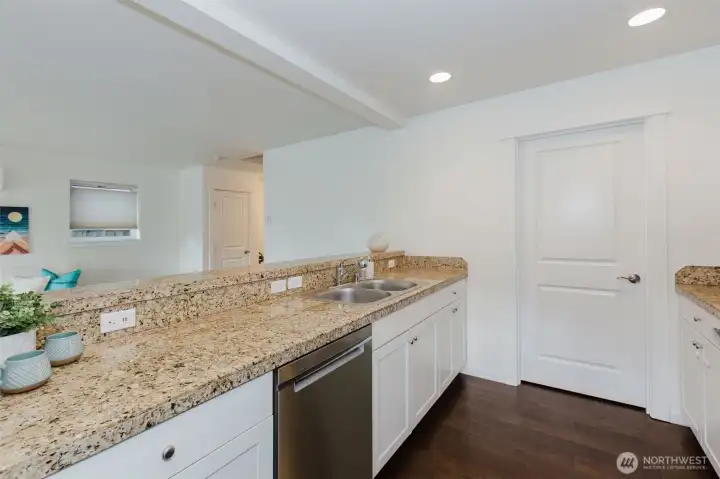 Kitchen with hard surface countertops, leads to a HUGE pantry.