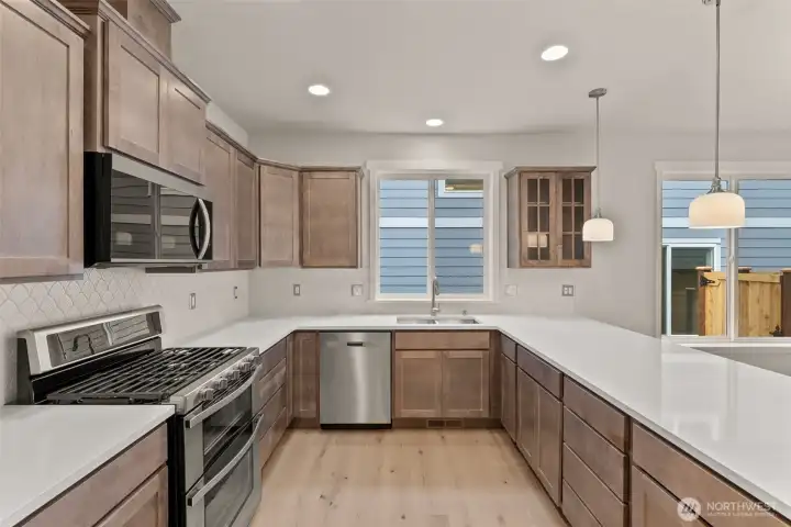 Stainless steel appliances include double oven range, dishwasher and microwave. Cabinet color to be Toffee not pictured here.