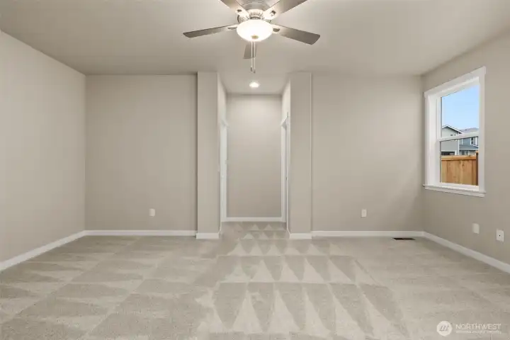 Inviting and spacious primary bedroom with ceiling fan for added comfort.