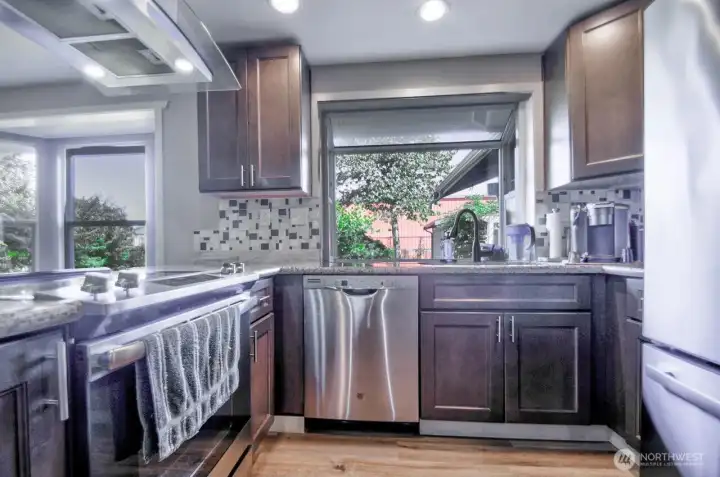 Another view of the updated kitchen with bay window and GE stainless steel appliances