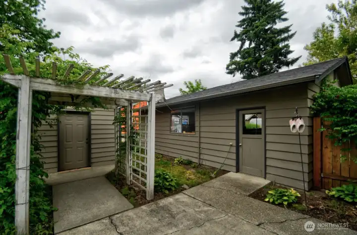 View of the shop door entrance on the right and shed on the left. Gate to the backyard (not in the picture) is on the right hand side of this view.
