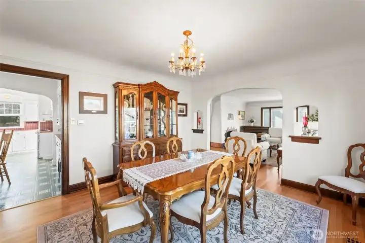 Formal Dining Room: Host memorable gatherings in this grand dining room. It features a vintage-style chandelier, large windows overlooking the yard, and a wide arched opening that connects to the living area.