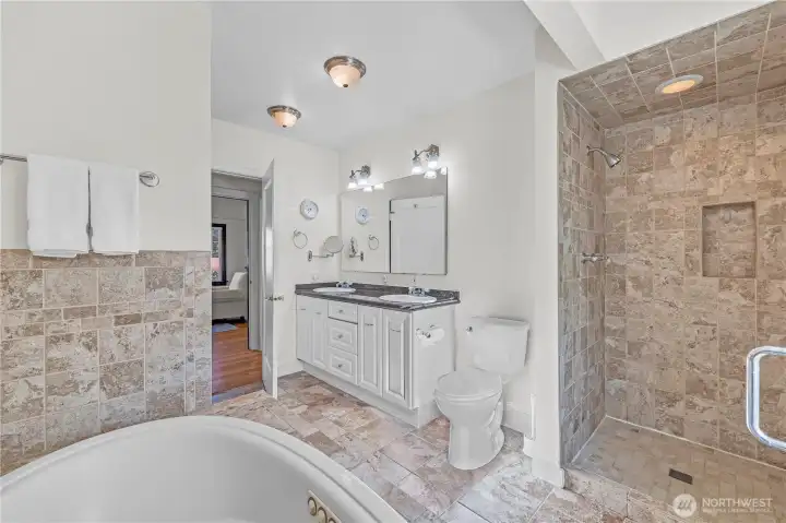 Luxury 5-Piece Bath: The spacious main-floor bathroom is a true sanctuary, complete with a jetted soaking tub, a tiled shower, and a dual-sink vanity with ample storage.
