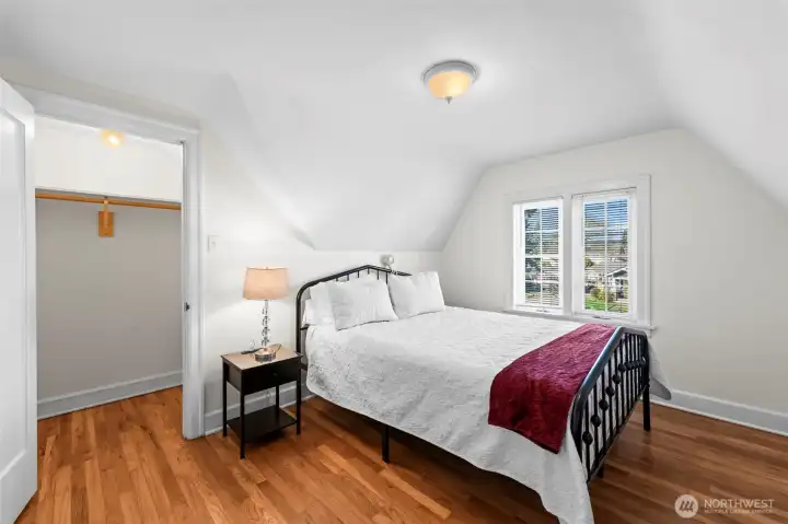 Secondary Bedrooms: The upper-level bedrooms are full of character, featuring sloped ceilings, original oak floors, and large windows that offer neighborhood views. A cozy room with plenty of closet space.