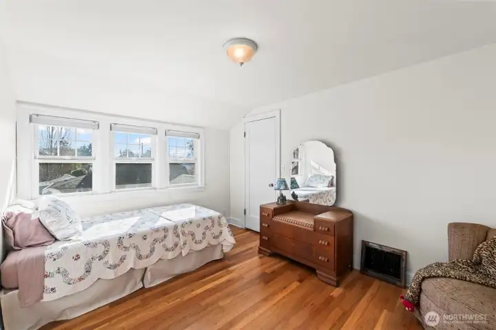 Secondary Bedrooms: The upper-level bedrooms are full of character, featuring sloped ceilings, original oak floors, and large windows that offer neighborhood views.