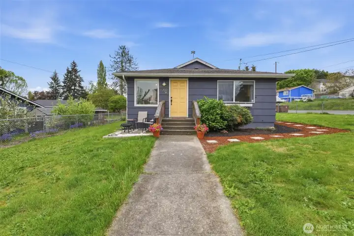 Charming Tacoma rambler with inviting front entry, clean landscaping, and easy access from sidewalk-lined street.